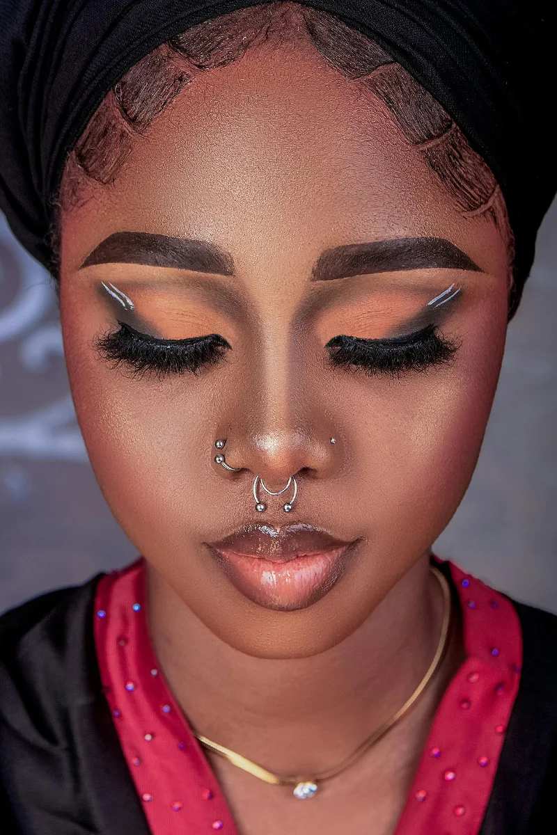 a portrait of a woman with a beautiful makeup and face piercing
