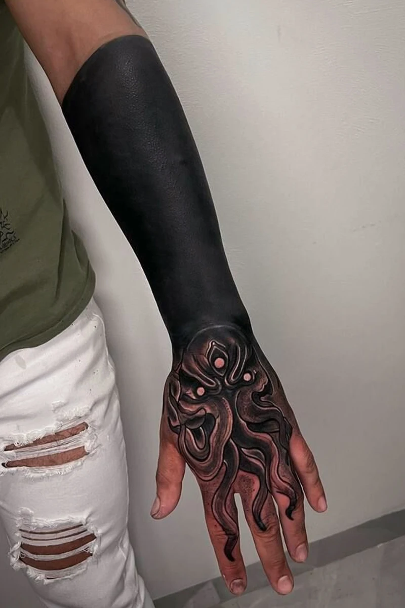 womans hand with a blackout tattooo
